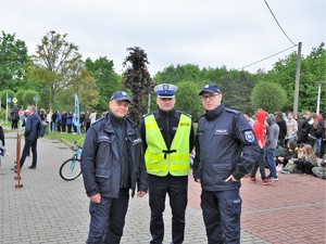 Zdjęcie przedstawia trzech policjantów pozujących do wspólnego zdjęcia.