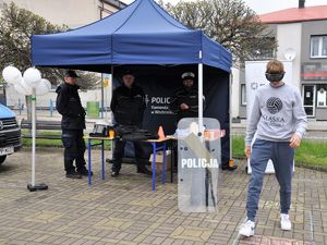 Zdjęcie przedstawia trzech policjantów oraz osobę, która próbuje przejść narysowany tor w alkogoglach.
