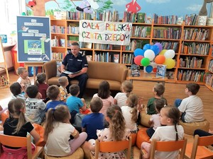 policjant czyta dzieciom książkę