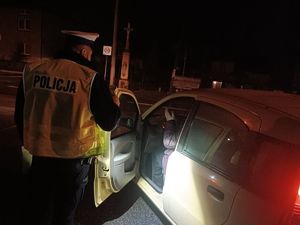 policjant podczas kontroli pojazdu w nocy